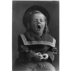   boy with long hair wearing hat,sailor coat yawning,c1909,curly hair