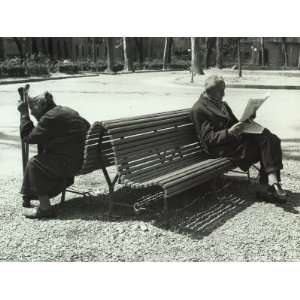  Elderly Man and Woman Sitting on a Bench in a Public 