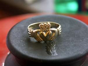 Beautiful gold Claddagh ring on a grey stone